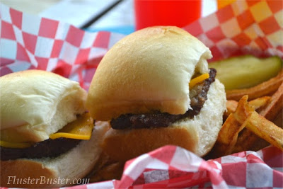 Simple Cheeseburger Sliders - Seasoned ground beef patties topped with cheddar cheese and served on a small sized bun.